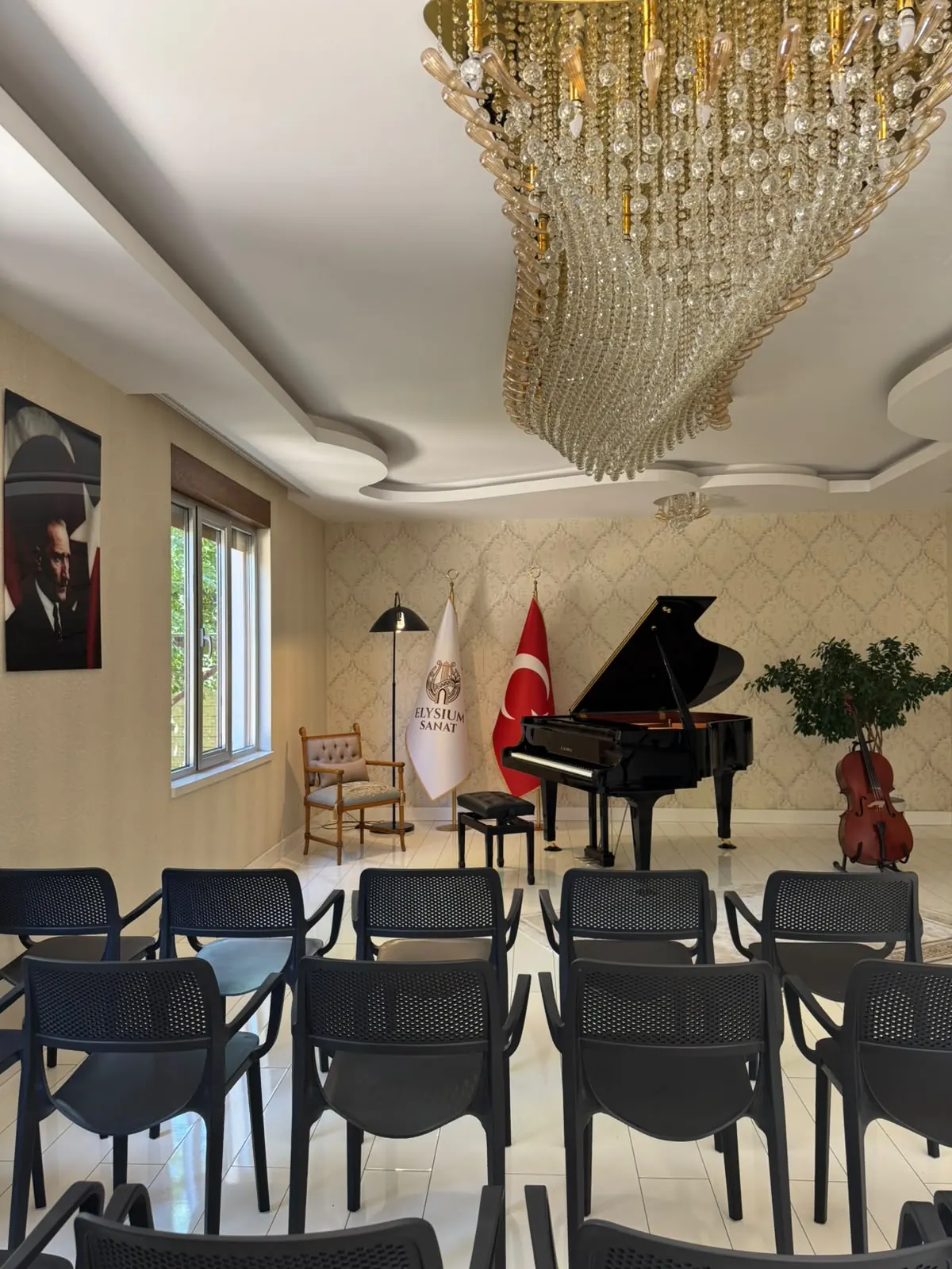 Elysium Sanat konser salonu — kristal avize altında kuyruklu piyano ve resital düzeni